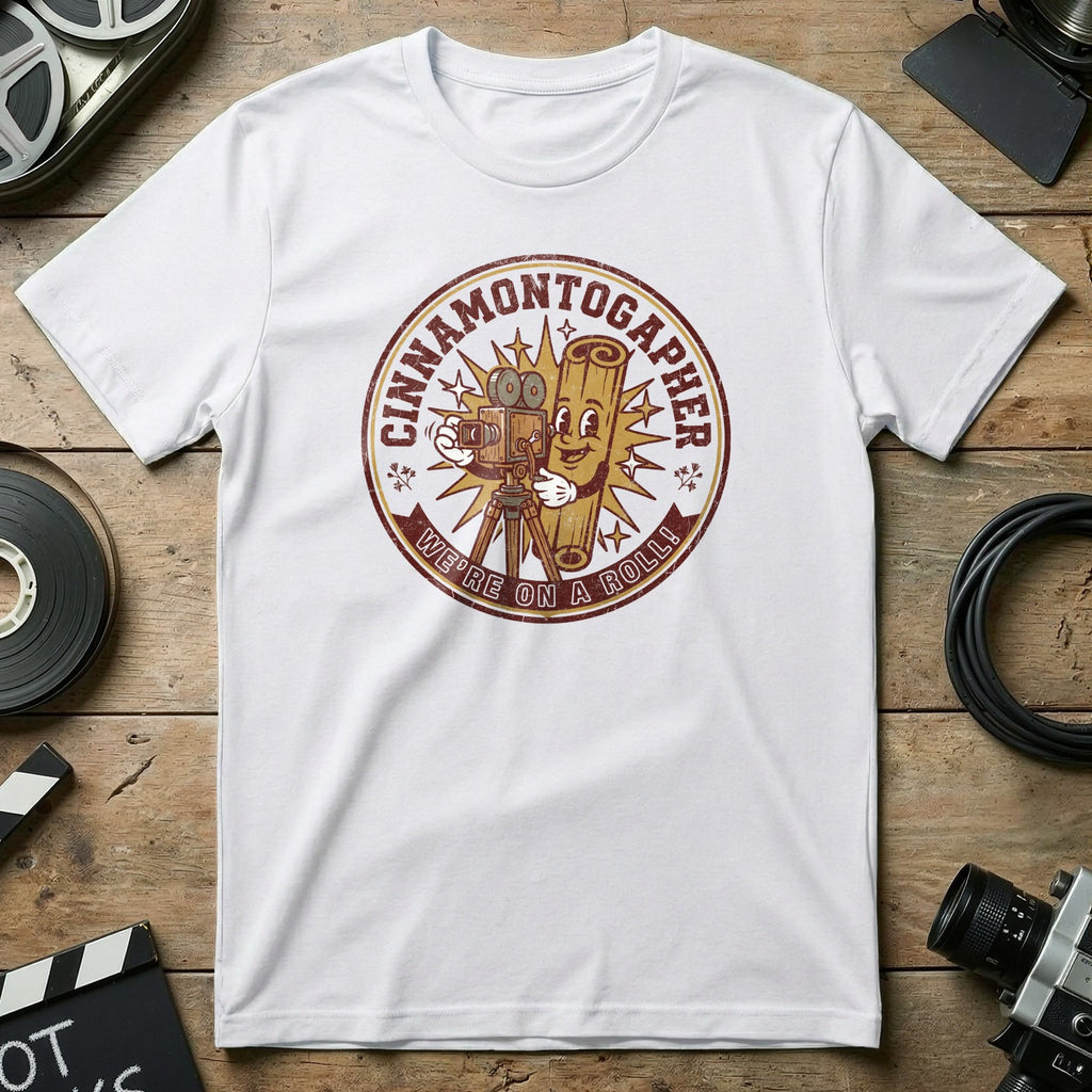 White t-shirt with a circular graphic featuring a cartoon cinnamon stick holding a vintage camera.