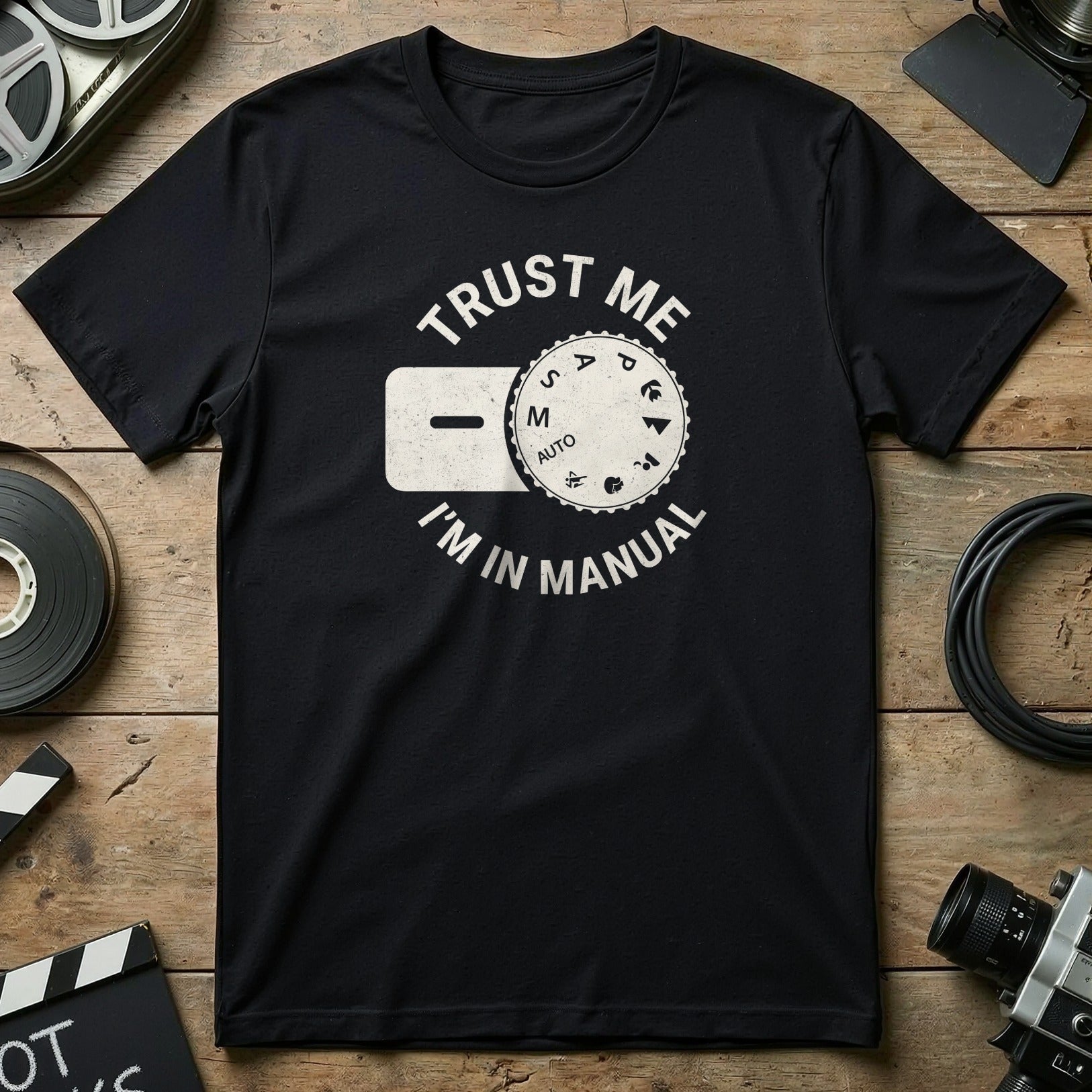 Black t-shirt with "Trust Me I'm in Manual" and camera dial graphic.