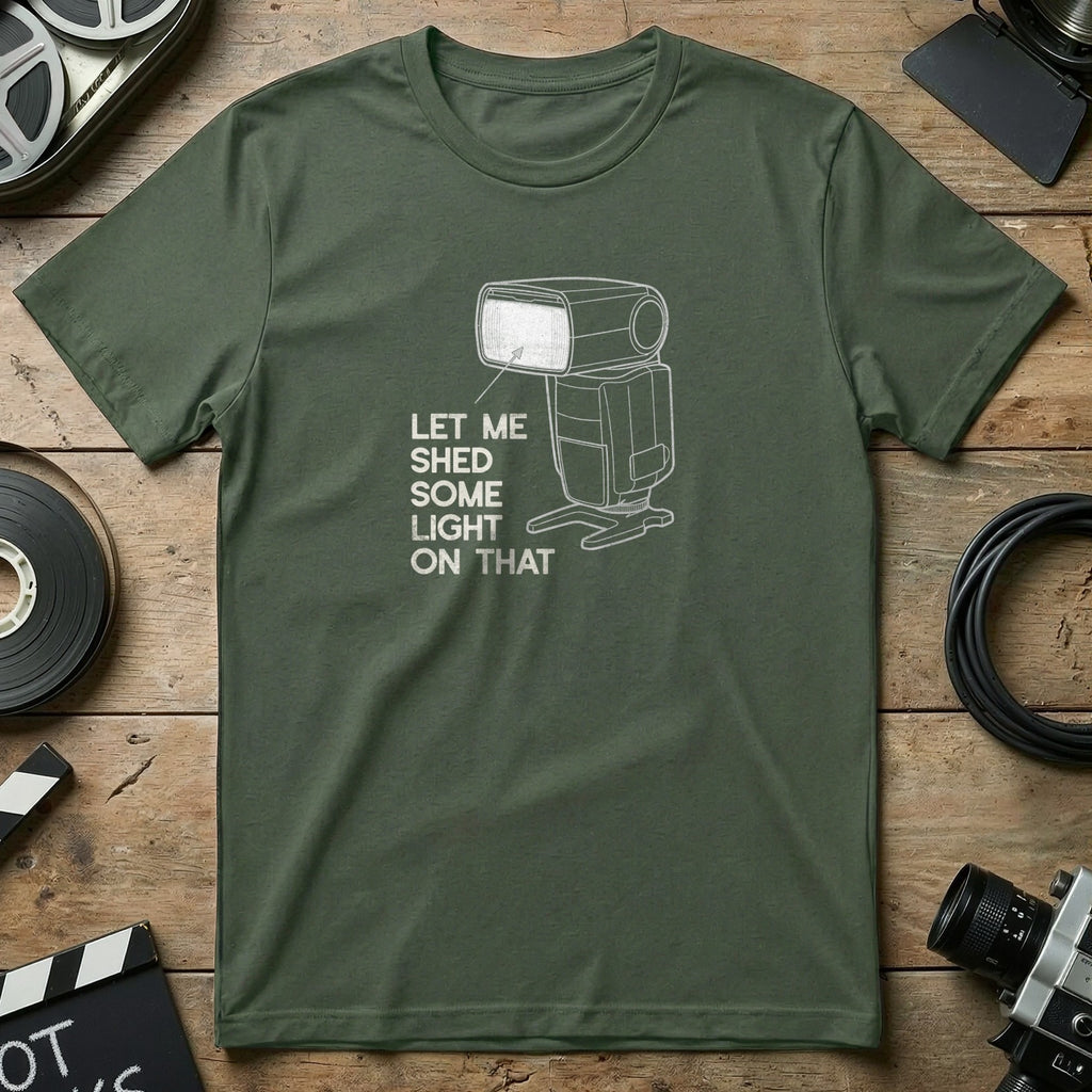 Green t-shirt with white line art of a camera flash and text "Let Me Shed Some Light On That".