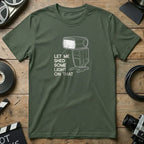 Green t-shirt with white line art of a camera flash and text "Let Me Shed Some Light On That".