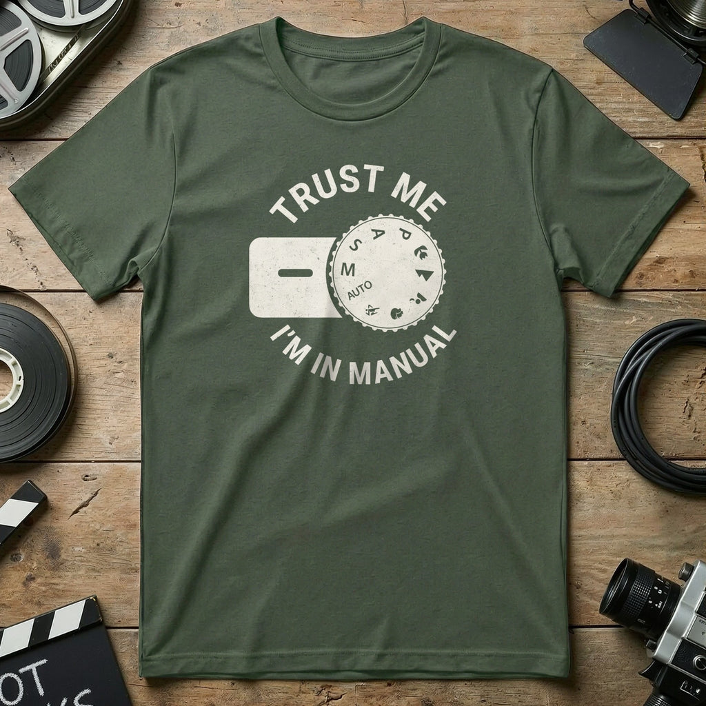 Green t-shirt with "Trust Me I'm in Manual" text and camera dial graphic.
