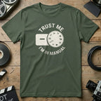 Green t-shirt with "Trust Me I'm in Manual" text and camera dial graphic.