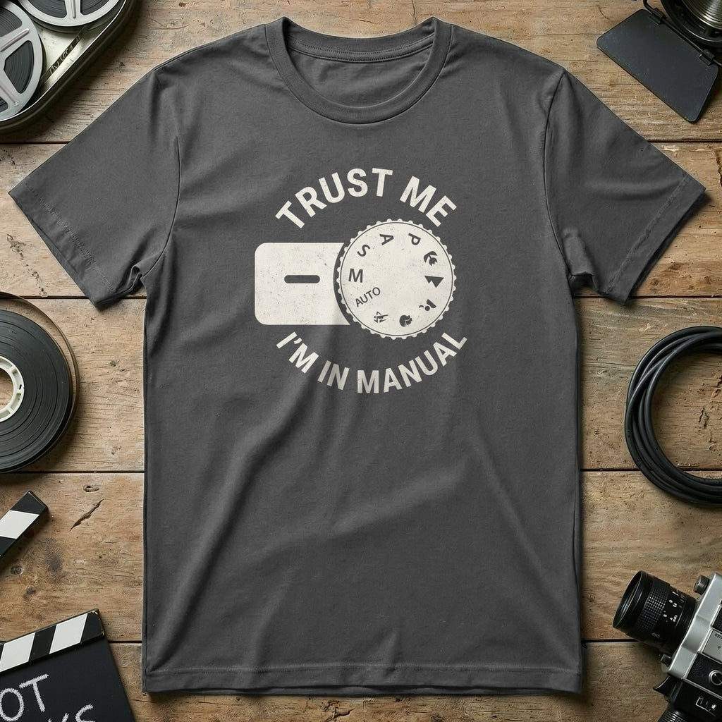 Dark grey t-shirt with "Trust Me I'm IN MANUAL" and camera dial graphic.