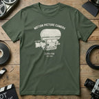 Green t-shirt with white "Motion Picture Camera SUPER PSR EST. 1967" graphic.