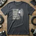 Dark grey t-shirt with a graphic of a spotlight and text "Let me shed some light on that".
