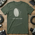 Green t-shirt with a graphic of a light fixture and text "Let's Keep It Light".