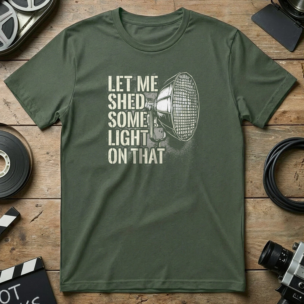 Green t-shirt with a spotlight illustration and text "Let me shed some light on that."