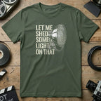 Green t-shirt with a spotlight illustration and text "Let me shed some light on that."