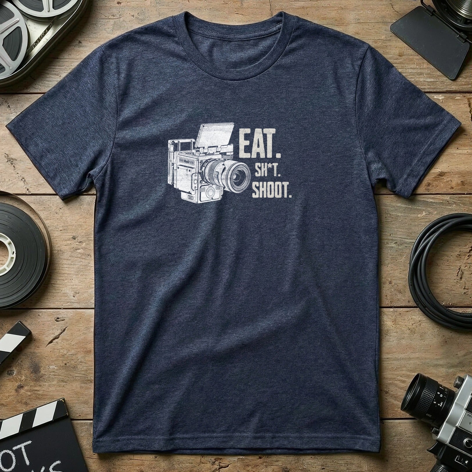 Dark blue t-shirt with "EAT. SH*T. SHOOT." text and vintage camera illustration.